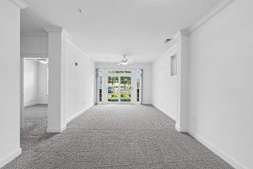 A long hallway with a carpeted floor and white walls.