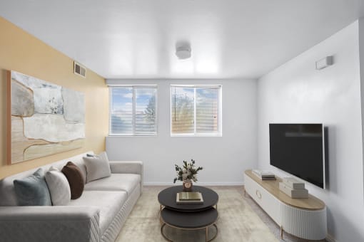 Virtually staged livingroom with couch, wall art, accent rug, coffee table,  television on tv stand, two windows, carpet, tan accent wall