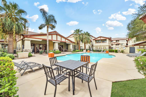 lounge chairs and table near swimming pool