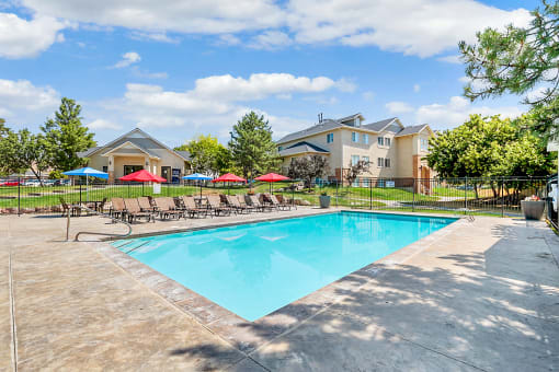 Pool with umbrella-covered tables and chairs