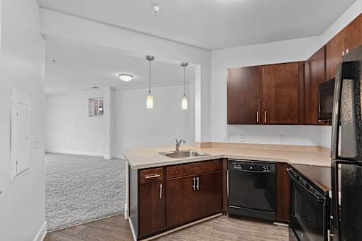 A kitchen with wooden cabinets and black appliances.