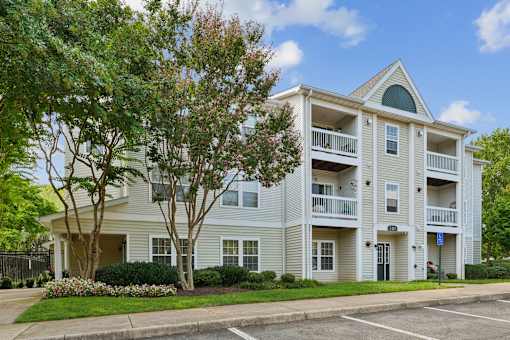 A two-story apartment building with a balcony on the second floor.