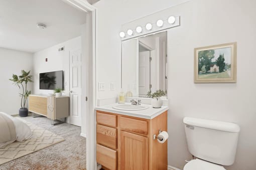 Bathroom vanity with large mirror and bedroom view at Rose Cove Homes Apartments, Farmington, UT 84025