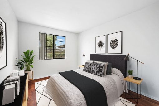 virtually staged bedroom with hardwood-style flooring and window