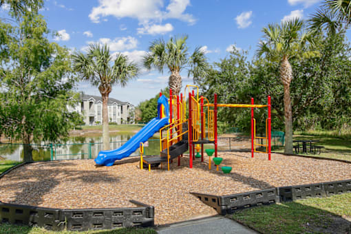 A playground with a blue slide and a yellow climbing frame.