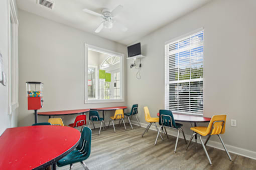 A room with a red table and chairs.