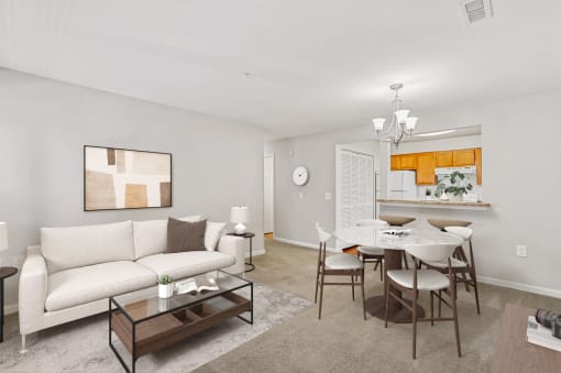 a living room with a white couch and a dining room table with chairs