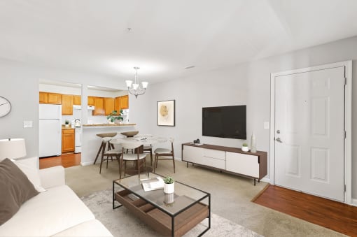 a living room with a white couch and a table with chairs in front of a flat screen