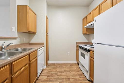 A kitchen with wooden cabinets and a white refrigerator.