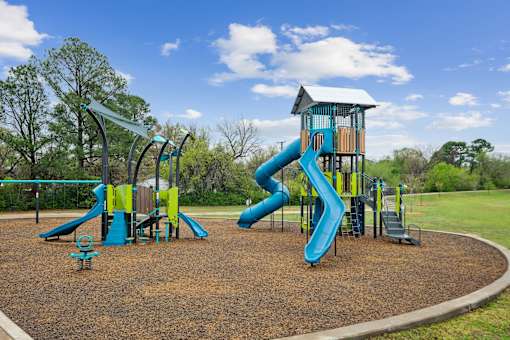A playground with a blue slide and a yellow slide.