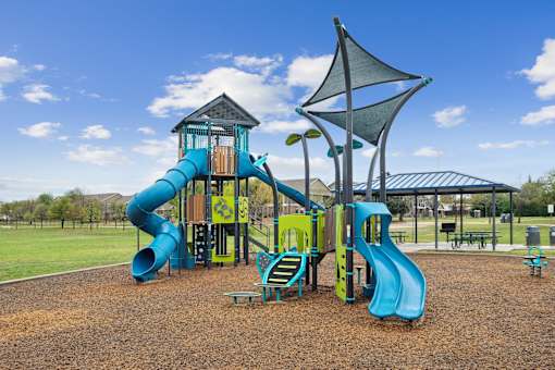 A playground with a blue slide and a yellow and blue play structure.