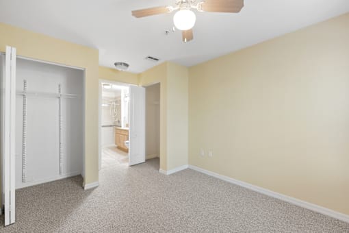 a bedroom with a ceiling fan and a closet