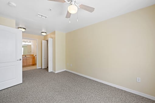 a bedroom with carpet and a ceiling fan