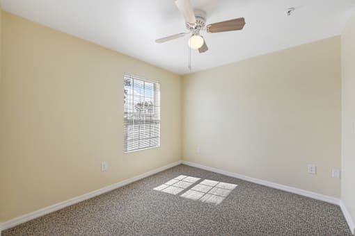 a bedroom with a ceiling fan and a window