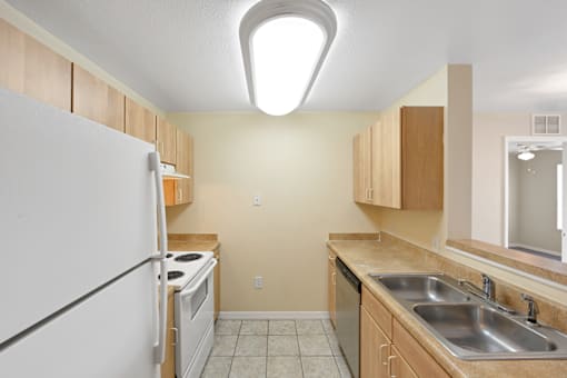 a kitchen with wood cabinets and white appliances