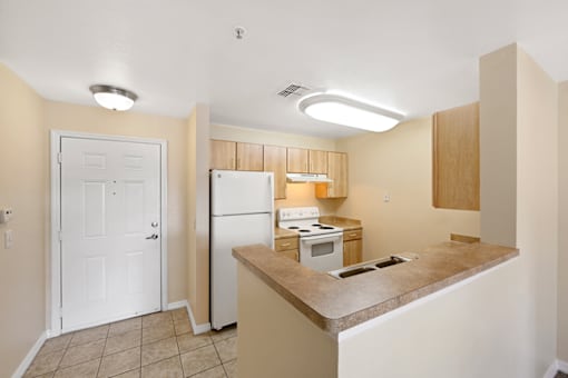 a kitchen with a white refrigerator freezer next to a stove top oven