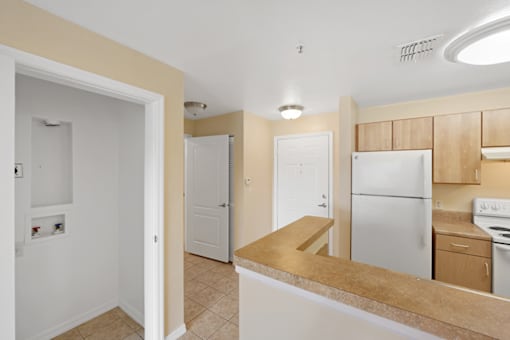 a kitchen with a white refrigerator freezer next to a white stove top oven