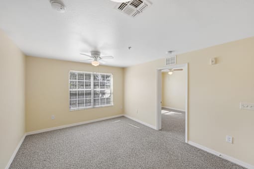 a bedroom with beige walls and a ceiling fan