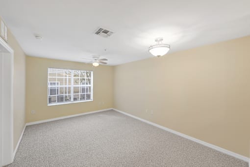 a bedroom with beige walls and a ceiling fan