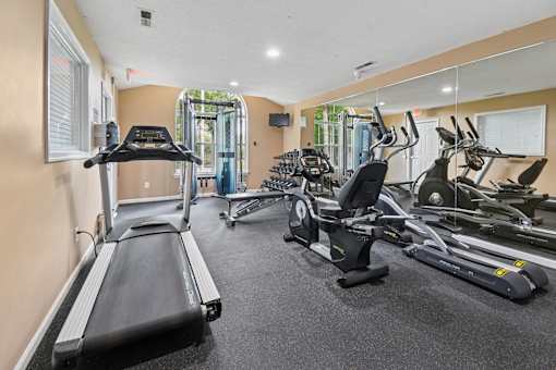 A gym with treadmills, elliptical machines, and other exercise equipment.