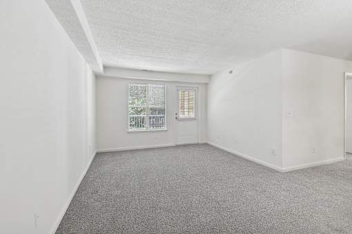 A room with a carpeted floor and a window.