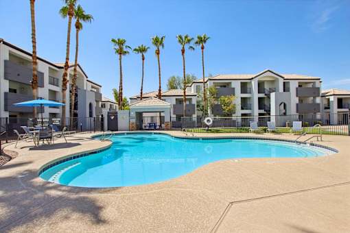 swimming pool with trees at The Village at Sun Valley Apartments, Mesa, AZ