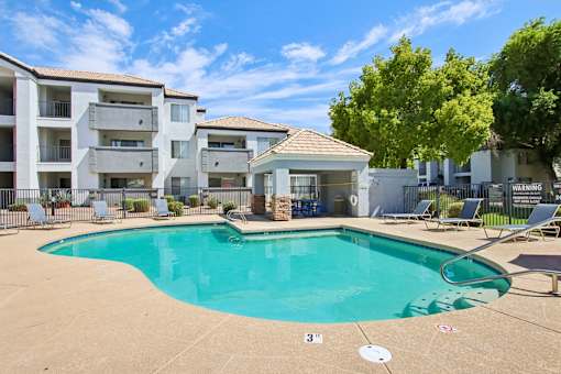 swimming pool with chairs at The Village at Sun Valley Apartments, Mesa, 85207