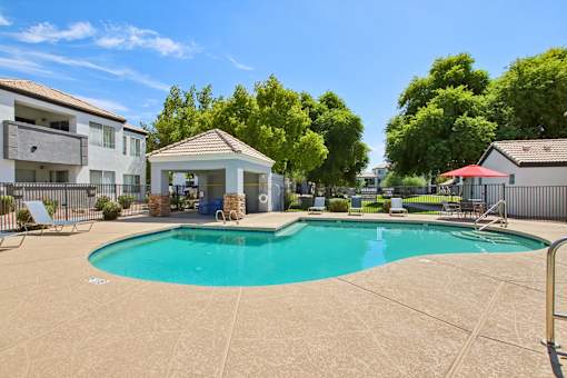 swimming pool with umbrella at The Village at Sun Valley Apartments, Arizona, 85207