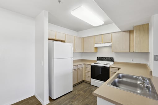 kitchen with a white refrigerator at The Village at Sun Valley Apartments, Arizona