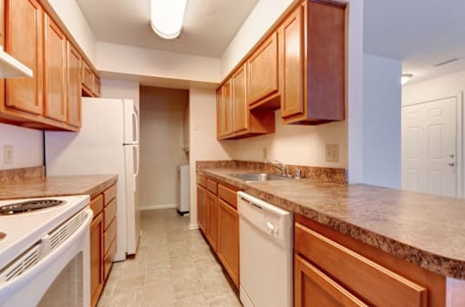 a kitchen with wooden cabinets and white appliances