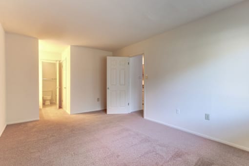 a bedroom with white walls and carpet