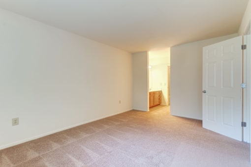 a bedroom with a carpeted floor and a white door