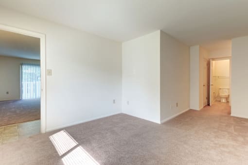 a bedroom with white walls and carpet