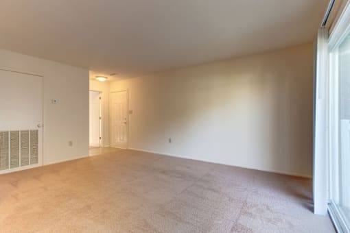 living room with a large window and beige carpet