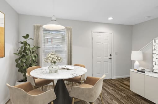 a dining area with a round table and four chairs