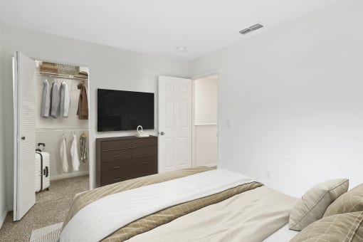 a bedroom with a large bed and a tv on the wall