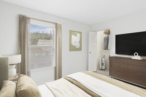 a bedroom with a large bed and a dresser with a television on top of it