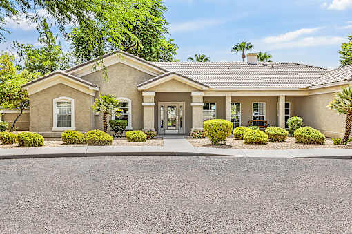Clubhouse entrance with desert landscaping and stucco facade at Tierra Antigua Apartments, Mesa, ARIZONA