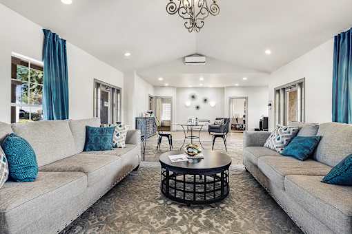 Spacious clubhouse lounge with vaulted ceiling and teal accents at Tierra Antigua Apartments, Mesa
