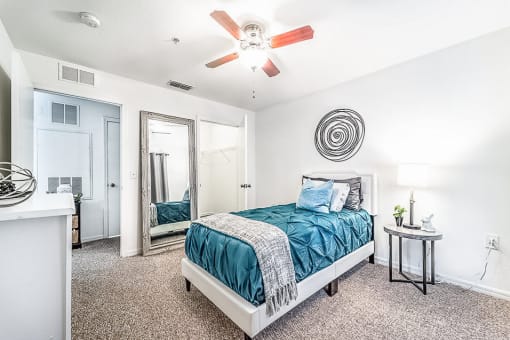 Modeled bedroom with carpet, a ceiling fan, and a closet.