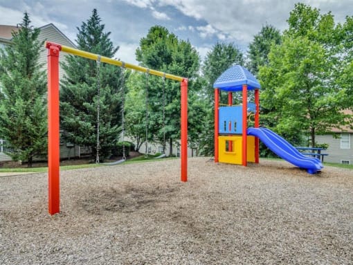 Playground on wood clips surrounded by building exteriors and trees
