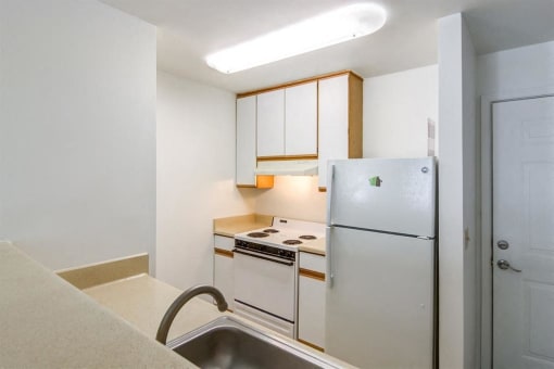 Kitchen with Wood Cabinet and White Cabinet and White Appliances Faces