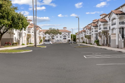 an empty street with white houses on either side