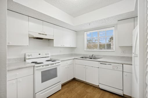 a white kitchen with white appliances and white cabinets