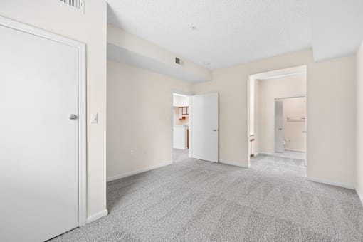 A large empty room with a carpeted floor and white walls.