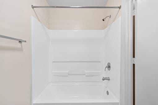 A white bathroom with a shower and a towel bar.