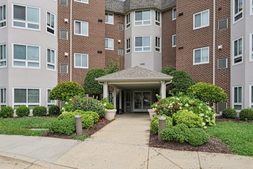 A building with a small entrance and a garden in front.