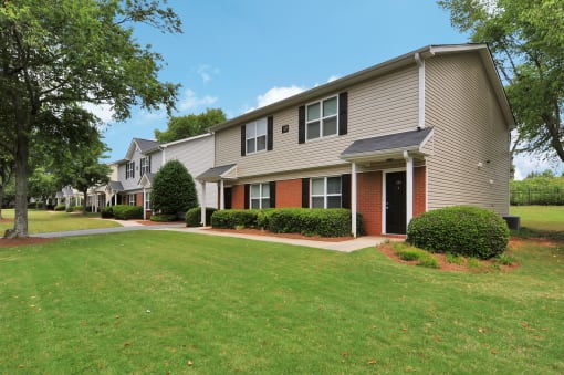 Building exterior featuring covered front door, large windows and paved walkway.