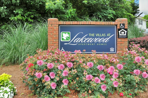 Community Sign for The Villas at Lakewood Apartment Homes surrounded by flowers and ferns.