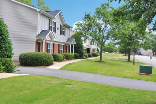 a row of houses on a street with a green lawn